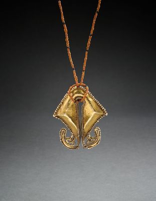 un gros plan d'un collier orné d'un pendentif en or