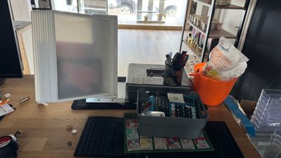 a desk with a computer monitor, keyboard, mouse, and other items on it