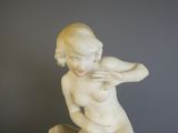 une statue de femme assise sur une table