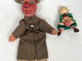 une poupée avec un visage de clown et une poupée sur laquelle se trouve une autre poupée