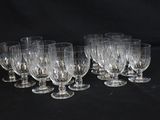 six verres à vin transparents sont alignés sur une surface noire