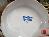 a woman holding a bowl that has a logo on it