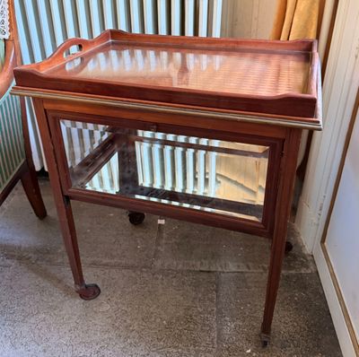 a small table with a glass top on a tile floor
