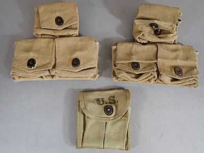 four tan canvas pouchs with buttons on them sitting on a table