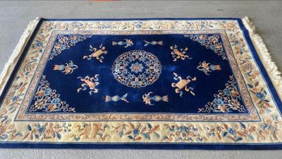 tapis oriental bleu posé sur la moquette dans une pièce dont le sol est recouvert de moquette