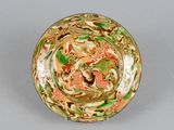 a green and orange bowl with a dragon design on it