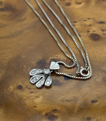 collier plaqué argent avec un pendentif en forme de libellule monté sur un support en bois