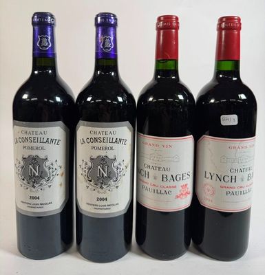four bottles of wine are lined up on a white surface