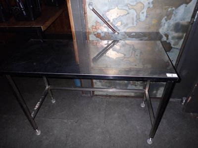 une table en métal avec un plateau en verre dans une pièce