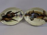 deux assiettes avec des oiseaux peints dessus, posées sur une table