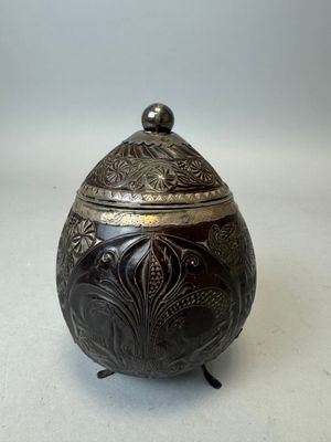 une boîte ancienne en métal argenté, ornée d'un motif floral sur le couvercle