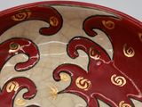 a red and gold plate with a horse design on it