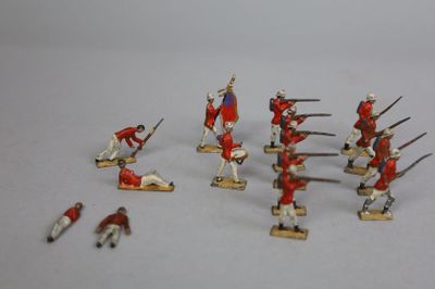 Plusieurs figurines de soldats en uniforme rouge sont disposées sur une surface blanche