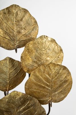 a vase with a bunch of gold leaves on it