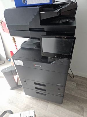 a black and white printer sitting on top of a pile of papers