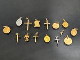 a collection of gold and silver crosses and coins on a black surface
