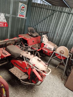 two red motorcycles parked next to each other in a garage