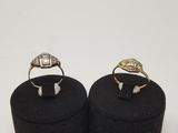 two gold and silver rings on black velvet boxes on a white background