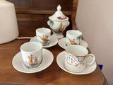 Plusieurs tasses et soucoupes sont posées sur une table en bois
