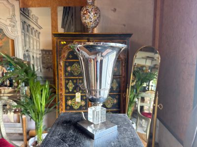 a silver vase sitting on top of a black table