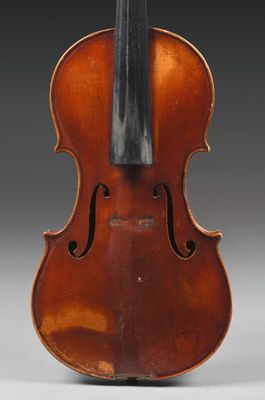 un vieux violon sur lequel repose un archet