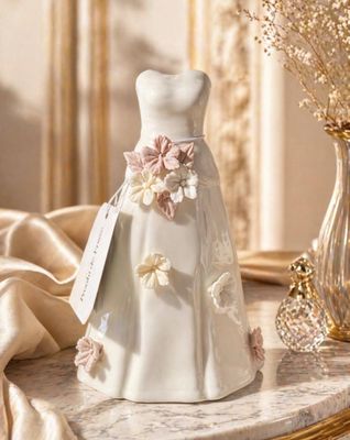 a vase with flowers and a dress on it on a table