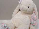a white stuffed animal with a bow on it ' s head
