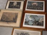 de nombreux tableaux encadrés posés par terre dans une pièce
