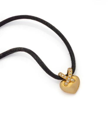 an image of a necklace with a gold heart on a black cord