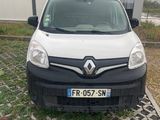une camionnette blanche garée devant un immeuble, sur un parking