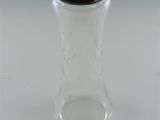 a glass jar with a silver lid on a white surface