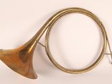 un vieil instrument en laiton muni d'un long cor, sur fond blanc