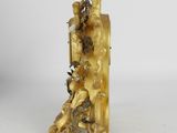 a gold figurine of a man and a woman sitting on a chair