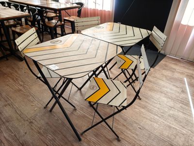 une table et des chaises dans une pièce au sol en parquet