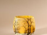 a close up of a small glass cup with trees on it
