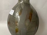 a glass vase with a black base and a label on it