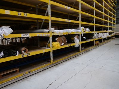 many shelves with rolls of paper on them in a warehouse
