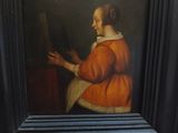 un vieux tableau représentant une femme tenant un miroir dans un cadre noir