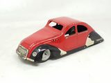 a red toy car that is sitting on a white surface