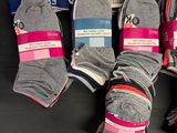 six pairs of gray and pink socks are on display in a box
