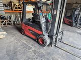 a red forklift in a warehouse with many pallets