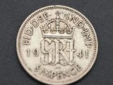 a close up of a silver coin with a crown on it
