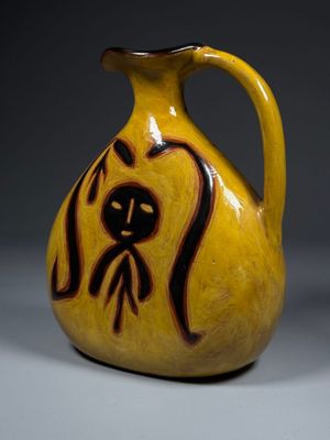 un vase jaune orné d'un motif noir et marron