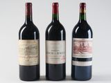 three bottles of red wine are lined up on a white surface