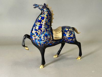 a blue and gold horse figurine on a white surface