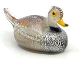 un canard en verre posé sur une surface blanche
