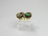 a gold ring with a green stone and two diamonds