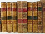 many old books lined up on a white surface