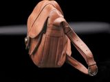 a small brown purse with a strap on a black surface