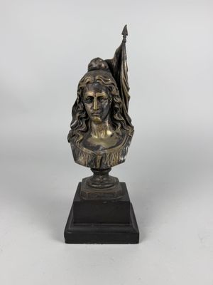 a bronze bust of a woman holding a flag on a black base
